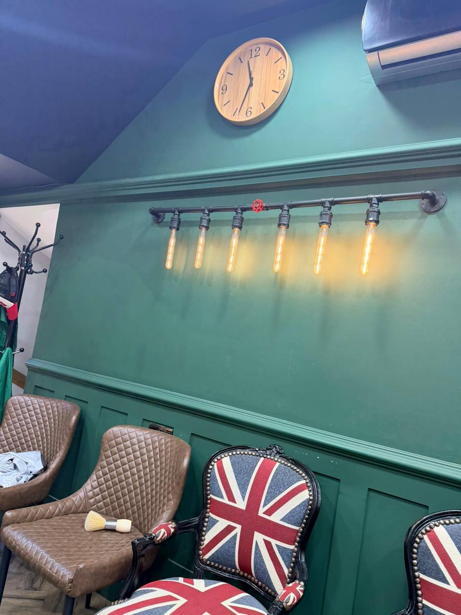 Inside Chaps & Crew — green walls, Edison bulbs and leather chairs